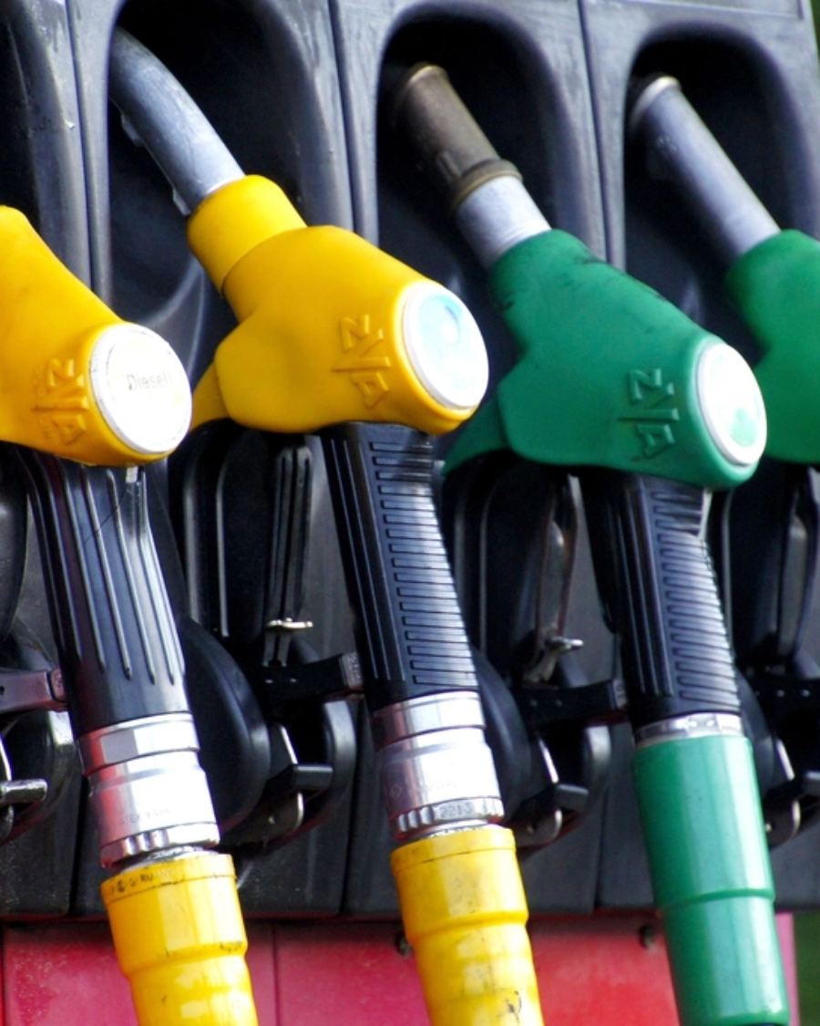 A petrol pump at a fuel station with a price display board