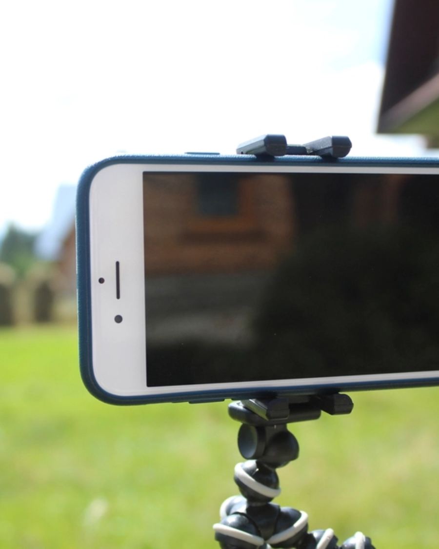 A phone showing a video call on a desk.