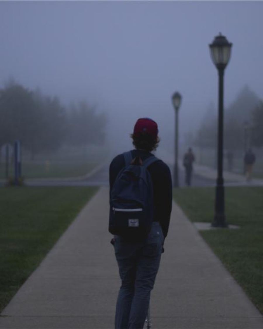 A child carrying a school backpack to the classroom